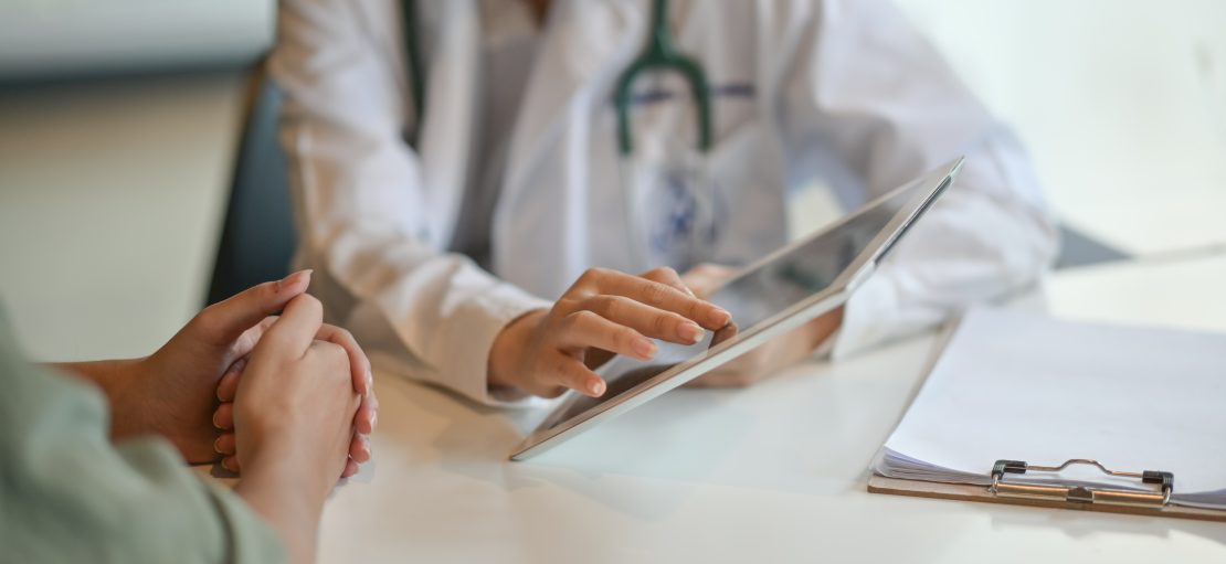 Shot of a doctor showing a patient some information on a digital tablet